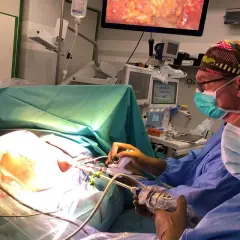 Chirurdzy podczas operacji. Na ekranie widać obraz z wnętrza ciała, co może być związane z zabiegiem mastektomii.