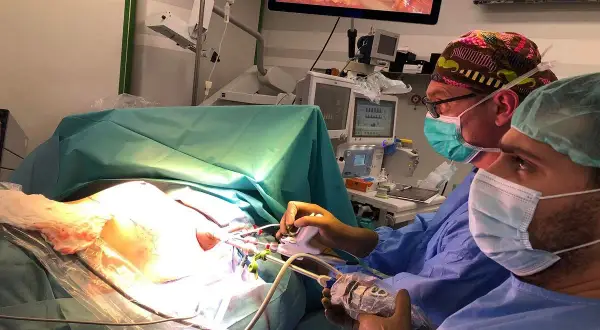 Chirurdzy podczas operacji. Na ekranie widać obraz z wnętrza ciała, co może być związane z zabiegiem mastektomii.